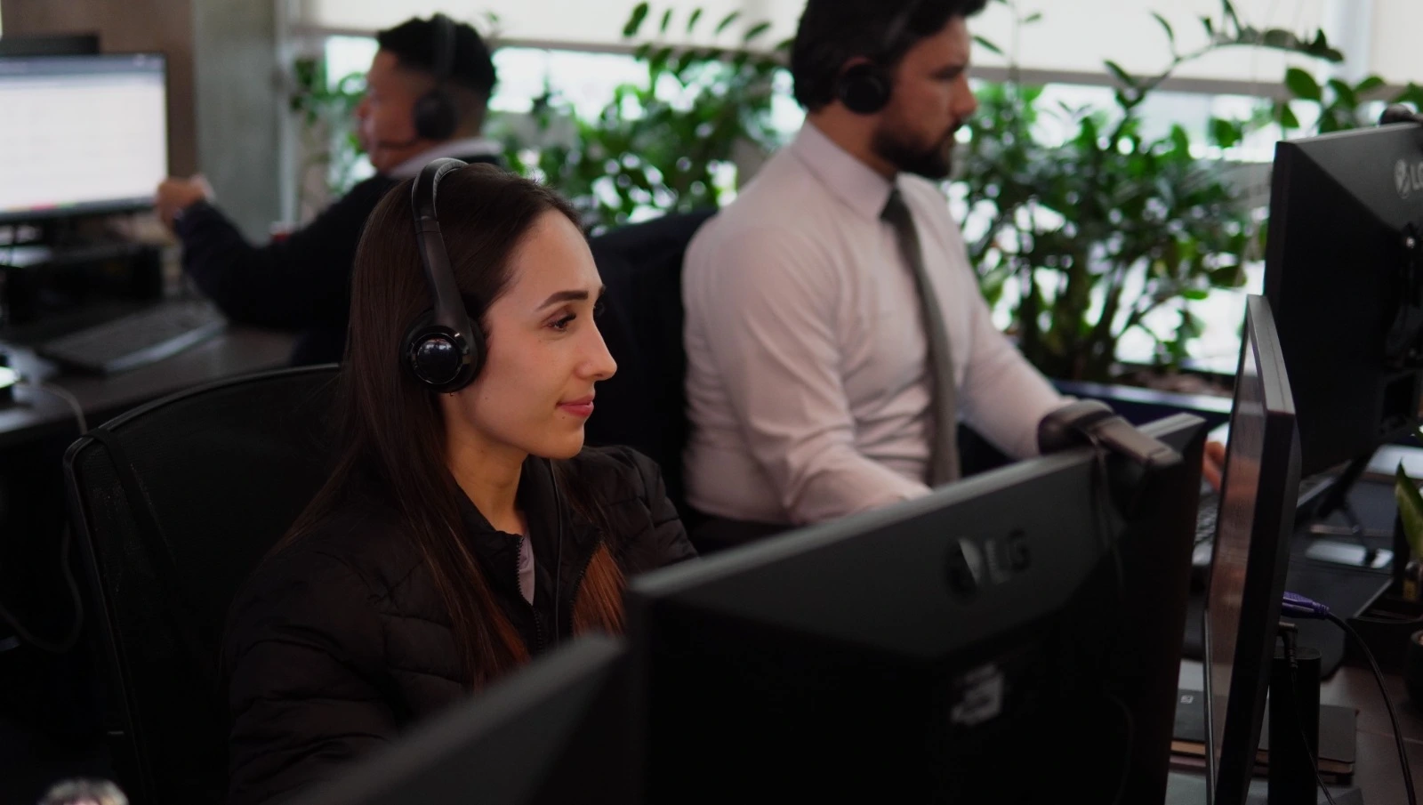 Equipe de assessores de investimentos da Ável em atendimento no escritório, com headset e monitores