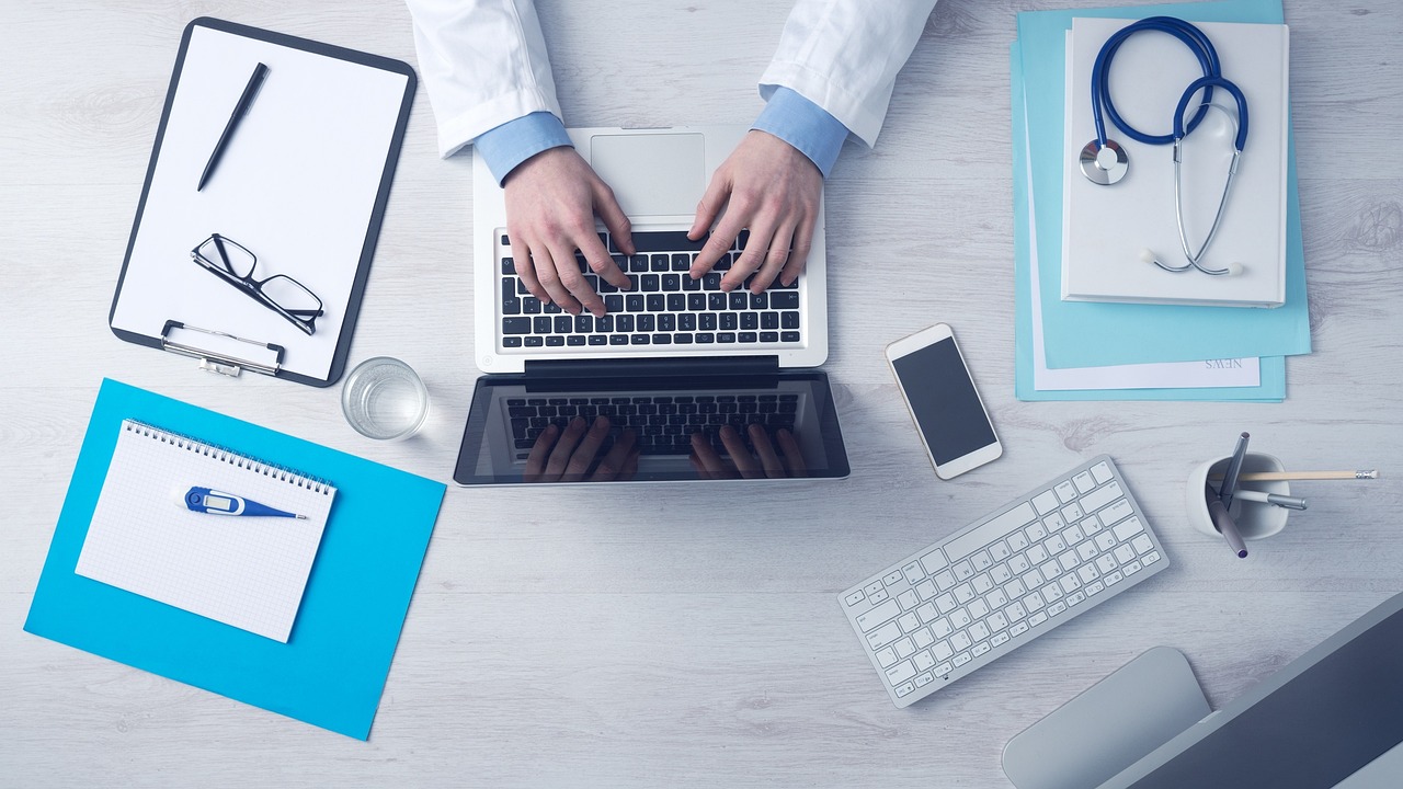 Médico olhando para o seu notebook e construindo uma boa aposentadoria para médicos.